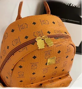 Close-up of brown pebbled leather texture and cute bear-shaped metal zippers on backpack