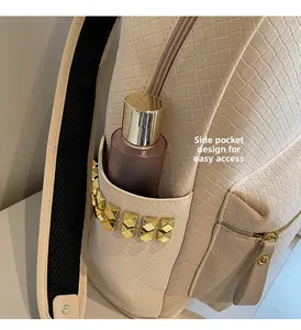 Detail of cream woven backpack side pocket with gold studs and skincare storage