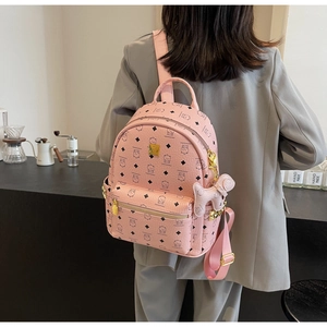 Detail of pink faux leather backpack with cartoon bear prints and puppy charm