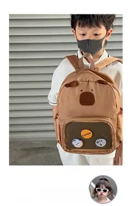 Detail of brown capybara backpack with bear ears, transparent pocket and decorative pins