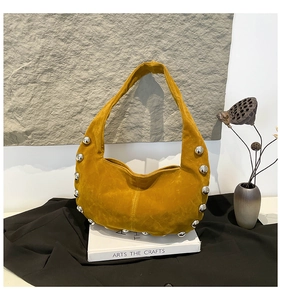 Dettaglio della borsa hobo in camoscio giallo con borchie argento in stile artistico