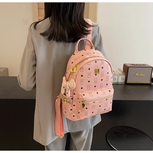 Detail of pink faux leather backpack featuring cute bear print and golden zipper