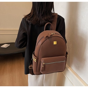 Detailed view of brown woven texture backpack with golden rivets and metal hardware accent