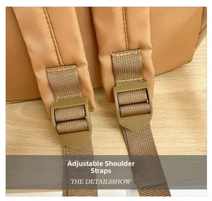 Detail of adjustable padded shoulder straps with durable plastic buckles on a brown backpack