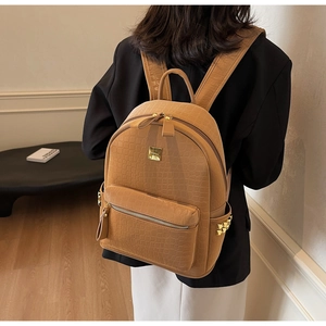 Chic brown crocodile embossed backpack with gold hardware and rivets on model