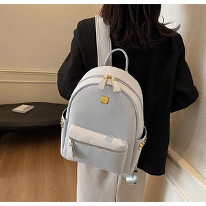 Detail of woven texture and golden zipper on this stylish minimalist grey backpack