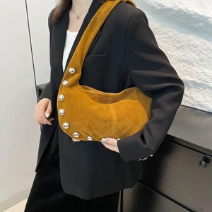 Borsa hobo in camoscio giallo con borchie argentate indossata da una modella