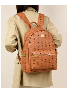 Detail showing caramel brown bear pattern backpack with golden rivets and metal plate