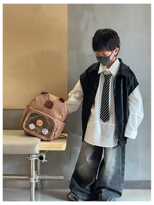 Close-up of cute brown capybara backpack with transparent PVC pocket and decorative badges