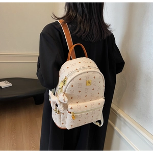 Lifestyle view showing the beige cartoon bear print backpack on a female model