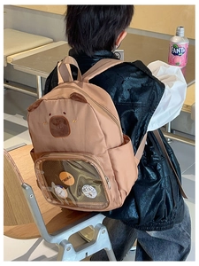 Detailed back view of a brown bear-themed schoolbag with a transparent clear pocket