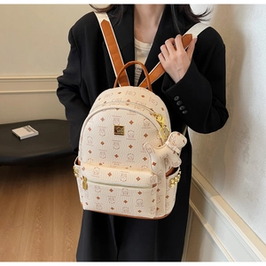 Close-up of golden rivets and cartoon bear monogram print on high-quality backpack