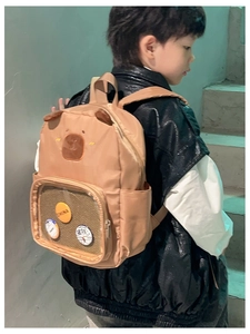 Detail of cute khaki kindergarten backpack with plush ears and transparent PVC front pocket