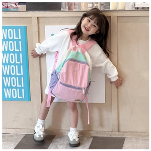 Girl wearing a colorful macaron patchwork backpack with pink and purple panels