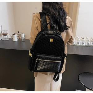 Detail of black woven texture backpack with metallic stud accents and zip closure