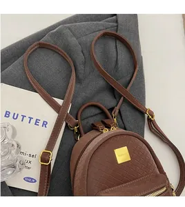 Detail of brown woven texture leather backpack with gold metal hardware and logo plaque
