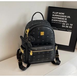 Detail of black mini backpack with bear print, gold studs and cute charm accessory
