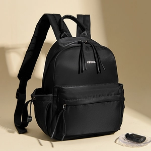 Close-up of black nylon backpack with LYSDL logo and long woven puller on the zipper