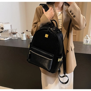 Fashionable black woven leather backpack with gold logo plate and side stud accents
