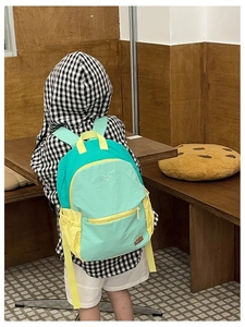 Detail shot of a color-block children's backpack in green and yellow tones for school kids