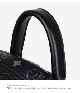Detail of black pebbled leather backpack showing bear print and monogram texture