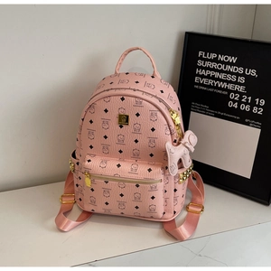Detail of pink faux leather backpack with cartoon bear prints and golden metal rivets