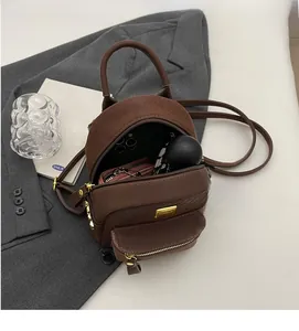Detail showing the brown woven leather backpack interior holding a phone and umbrella