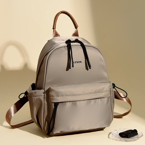 Detail of waterproof nylon backpack showing metallic logo and premium fabric texture