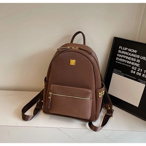 Detail of dark brown woven texture PU leather backpack with gold rivets and zippers