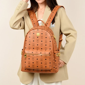 Detailed view of caramel leather backpack with floral bear pattern and gold studs on side