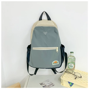 Detail of blue and beige contrast backpack with front zipper pocket and side pockets