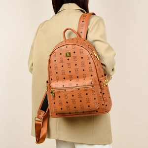 Caramel brown leather backpack with bear prints and gold rivets on a model's back