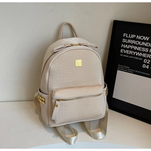 Detail of cream backpack showing crocodile texture leather and elegant bow zipper puller
