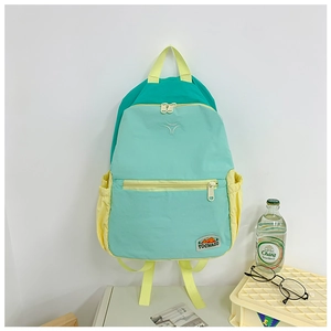 Detail of color-block backpack with mint green fabric and yellow zipper side pocket