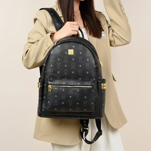 Detail of black printed backpack featuring gold studs and luxury square logo plaque