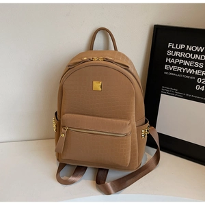 Detail of brown crocodile pattern backpack featuring gold rivets and VICI metal logo