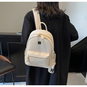 Detail of off-white woven leather backpack with gold zippers and stylish metal rivets