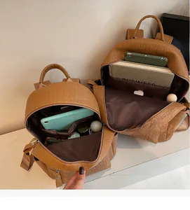 Detail view of brown crocodile texture leather backpack with spacious interior storage