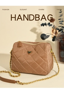 Détail du sac bandoulière matelassé marron avec chaîne dorée et logo en métal