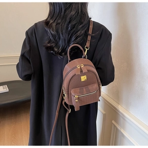 Brown quilted mini backpack for women worn as a crossbody bag with gold hardware detail