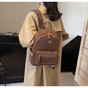 Detail view of brown woven texture backpack with golden zipper and luxury metal studs