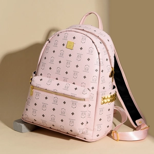 Detailed view of pink backpack with bear pattern, quilted texture and golden side rivets