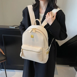 Fashionable beige faux crocodile skin backpack for women with gold hardware and rivets