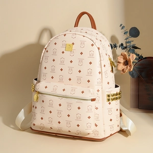 Detail view of stylish cream backpack with cute bear print and golden rivet accents