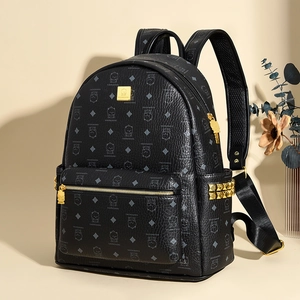 Detail view of black pebble leather backpack with gold rivets and cute bear pattern