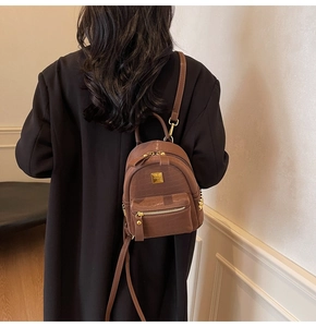 Detail view of brown crocodile texture mini backpack with gold rivets and metallic logo