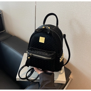 Close-up of black woven leather mini backpack with gold hardware and logo detail