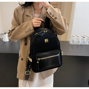 Detail of black woven texture backpack featuring premium gold hardware and front zipper pocket