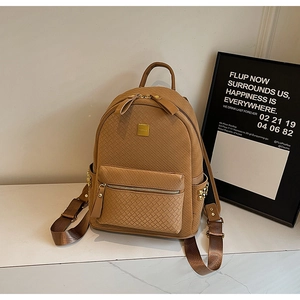 Detail of brown woven texture backpack with gold metal logo and side rivet accents