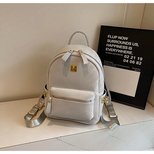 Detail of light gray woven leather texture with elegant gold hardware on casual backpack